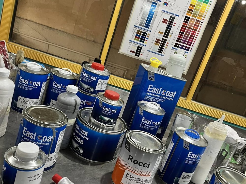 Bodyshop mixing bench with EasiCoat primers, thinners and a Rocci 2K white tin beside a colour chart